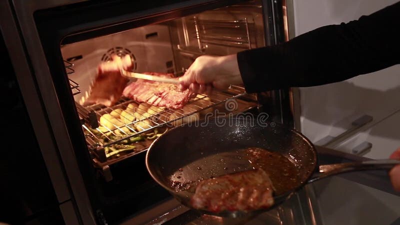 Cozimento de bife e bifes de porco em forno Carne assada, vapor do prato, foco seletivo