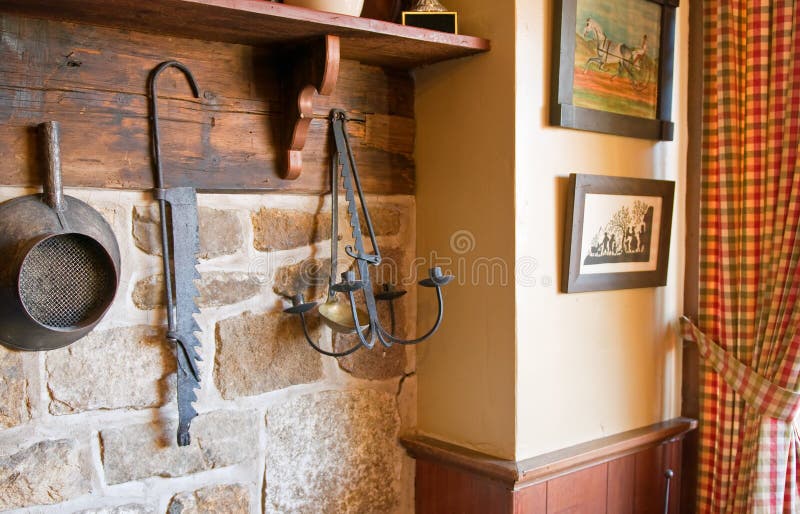 A collection of old antique tools hung on a country kitchen wall. A collection of old antique tools hung on a country kitchen wall.