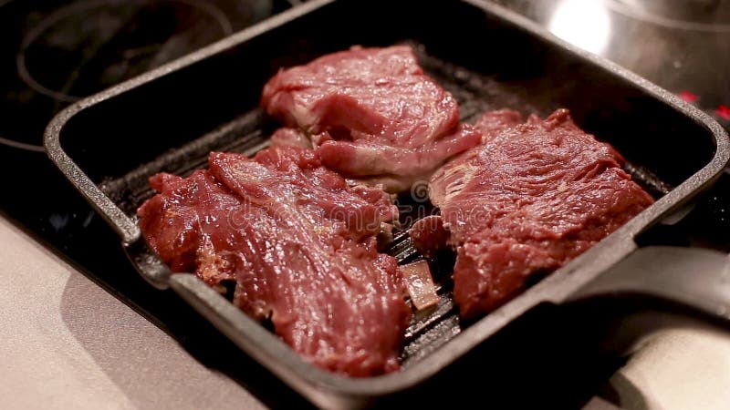 Cozinhando bifes da carne e da carne de porco na bandeja da grade