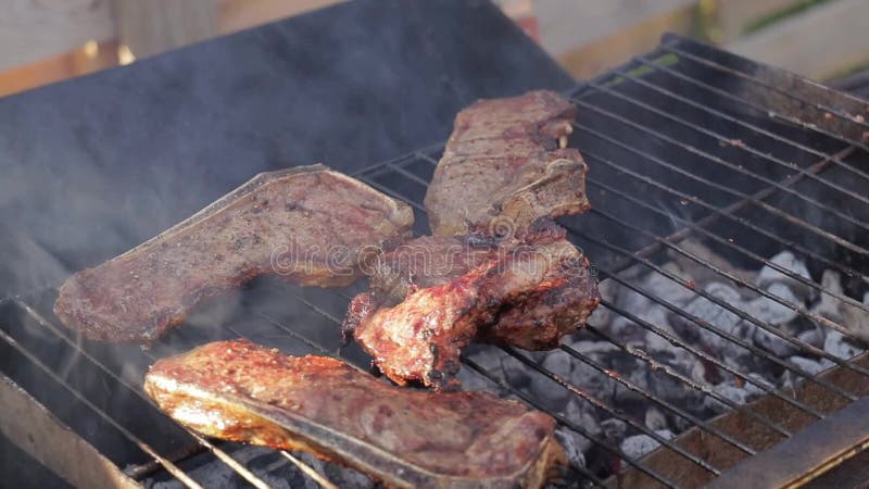 Cozinhando bifes em uma grade do assado