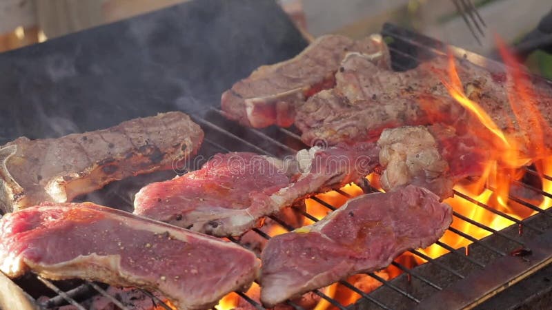 Cozinhando bifes em uma grade do assado