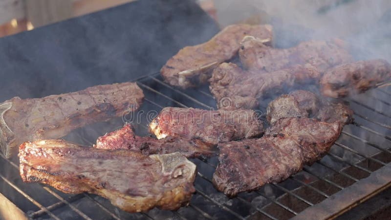 Cozinhando bifes em uma grade do assado