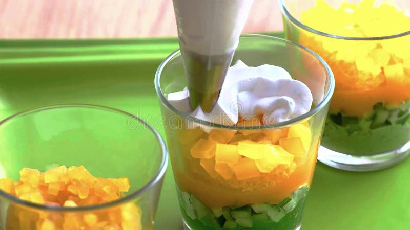 Cozinhando a sobremesa de creme em um vidro, mergulhado com camadas de frutos e de porcas o cozinheiro espalha as camadas fotos de stock Cozinhando a sobremesa de creme em um vidro, mergulhado com camadas de frutos e de porcas o cozinheiro espalha as camadas fotos de stock