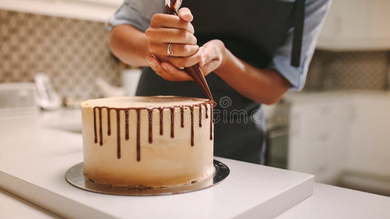 Cozinheiro chefe de pastelaria que decora um bolo