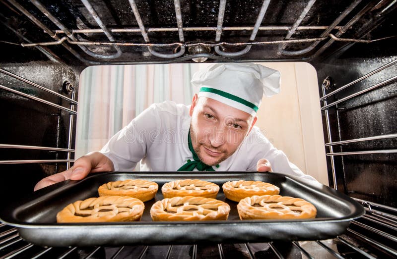 Cozinheiro chefe que cozinha no forno foto de stock Cozinheiro chefe que cozinha no forno foto de stock