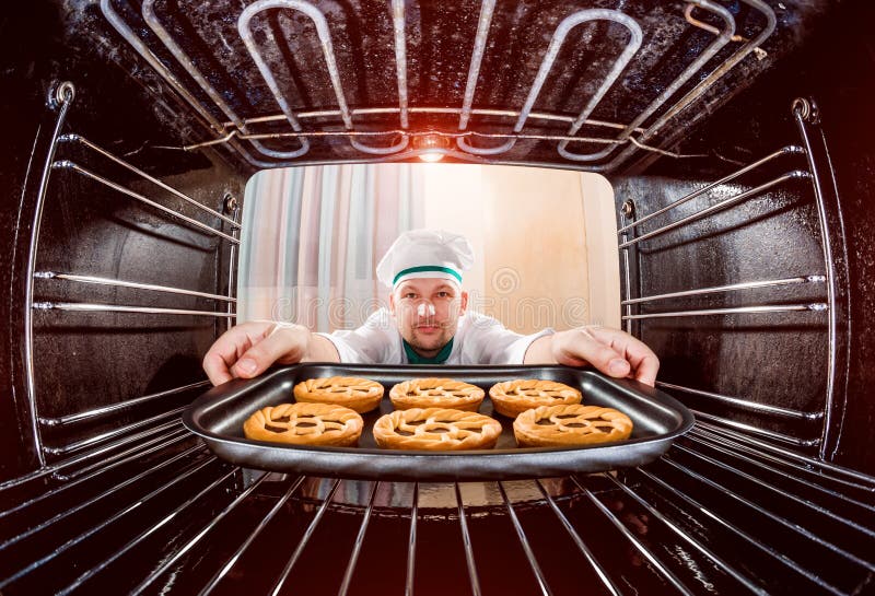 Cozinheiro chefe que cozinha no forno foto de stock Cozinheiro chefe que cozinha no forno foto de stock