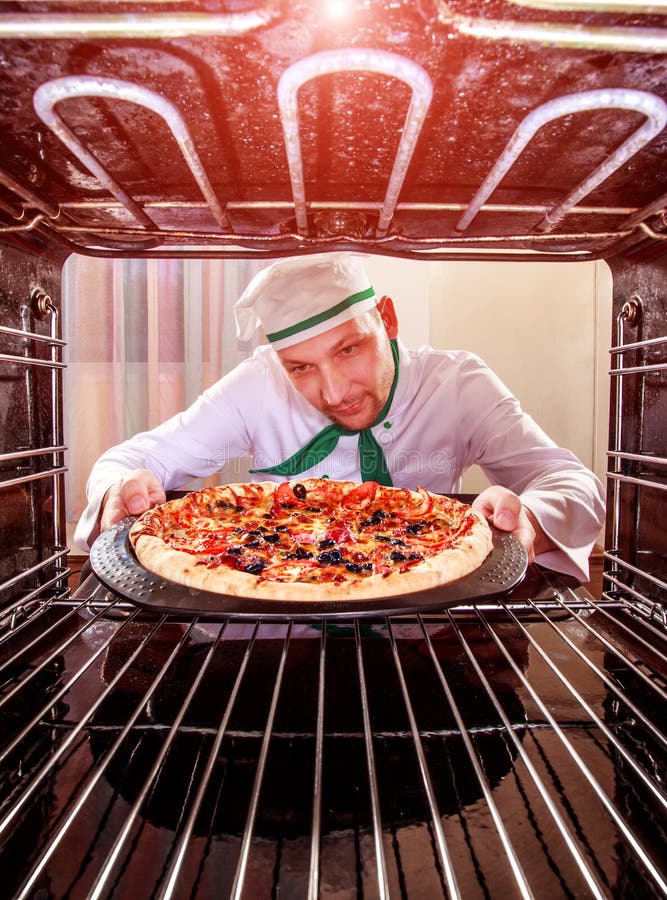 Cozinheiro chefe que cozinha a pizza no forno