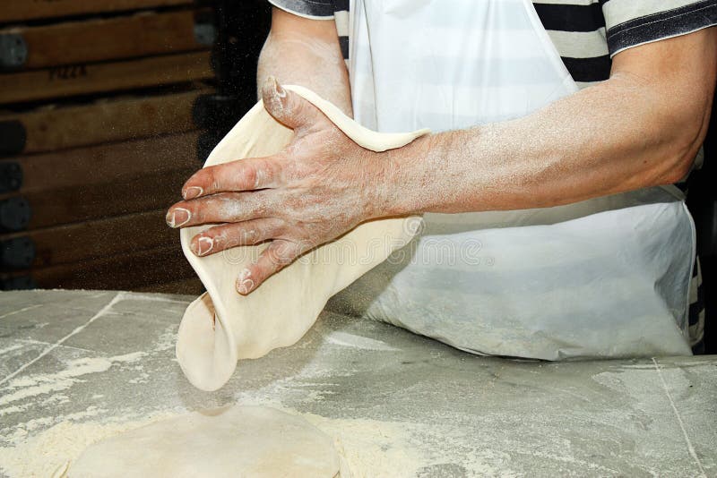 Cozinheiro chefe que dá forma à massa de pão da pizza