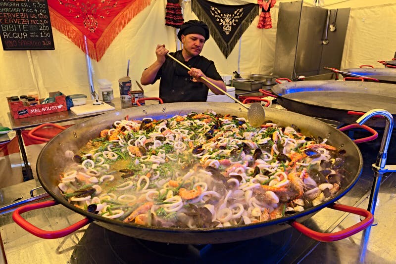 Cozinheiro chefe que prepara o paella fotografia de stock Cozinheiro chefe que prepara o paella fotografia de stock