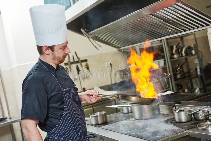 Cozinheiro do cozinheiro chefe que faz o flambe foto de stock Cozinheiro do cozinheiro chefe que faz o flambe foto de stock