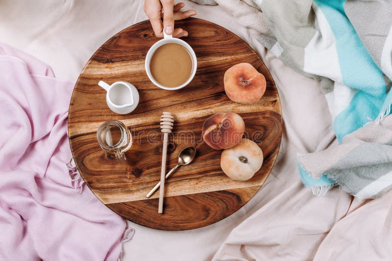 Cozy autumn or winter flatlay of wooden tray with cup of coffee, peaches, creamer with plant milk royalty free stock image Cozy autumn or winter flatlay of wooden tray with cup of coffee, peaches, creamer with plant milk royalty free stock image