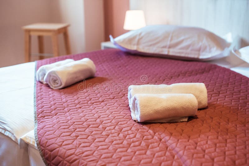 Cozy Bedroom Interiors with Fresh Linens Soft Pillows and RollTowels in Warm and Investigation Spaces Perfect for Relaxation and arkivbild