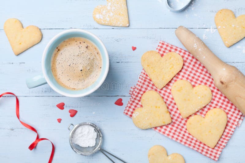 Cozy breakfast for Valentines day. Cup of coffee and sweet cookies in shape of heart top view.