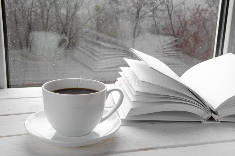 Cozy winter still life: cup of hot coffee and opened book on vintage  windowsill against snow landscape from outside Stock Photo - Alamy