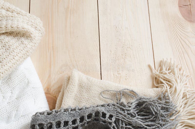 Cozy and soft winter background. Warm knitted clothes on a wooden background. Holidays at home. Selective Focus.