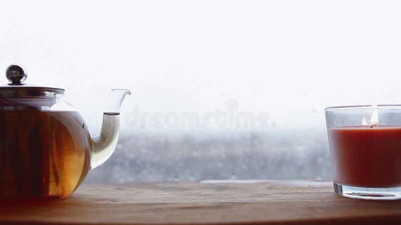 Cozy still life. Autumn weather, stormy and raining outside window. Cozy tea.