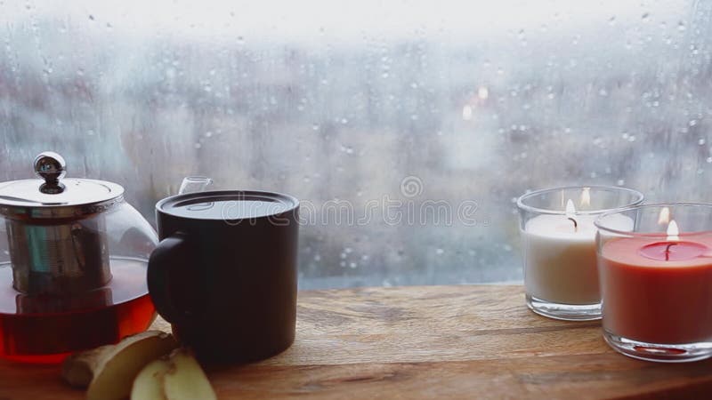 Cozy still life. Autumn weather, stormy and raining outside window. Cozy tea.