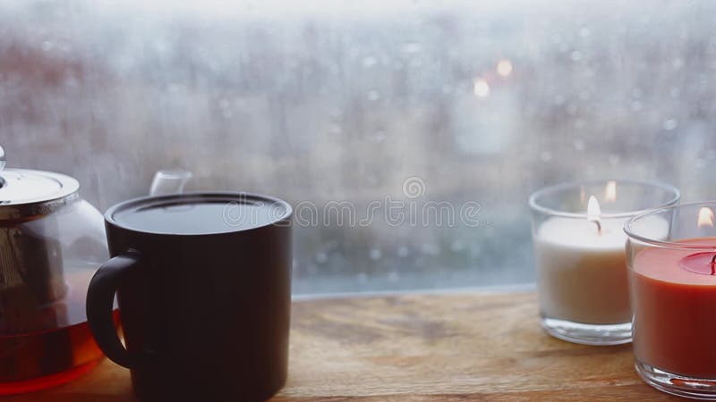 Cozy still life. Autumn weather, stormy and raining outside window. Cozy tea.