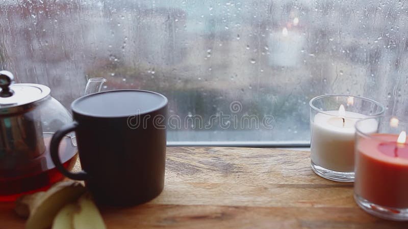 Cozy still life. Autumn weather, stormy and raining outside window. Cozy tea.