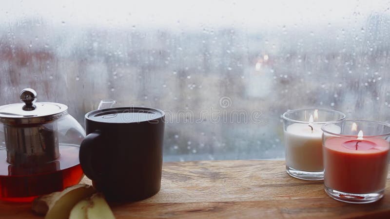Cozy still life. Autumn weather, stormy and raining outside window. Cozy tea.