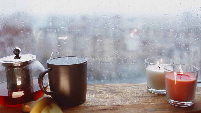 Cozy still life. Autumn weather, stormy and raining outside window. Cozy tea.