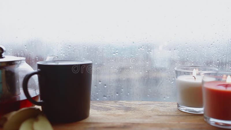 Cozy still life. Autumn weather, stormy and raining outside window. Cozy tea.