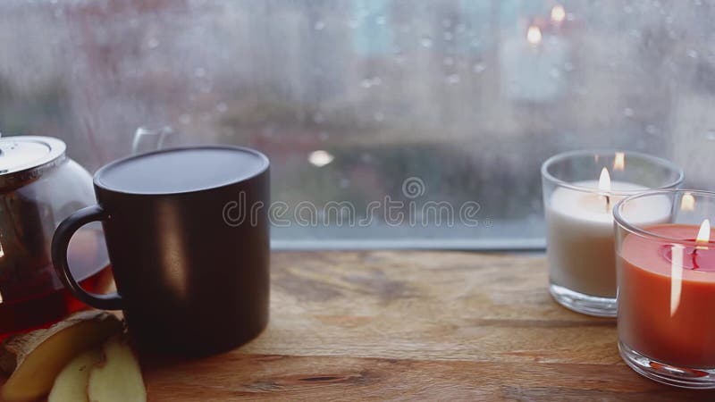 Cozy still life. Autumn weather, stormy and raining outside window. Cozy tea.