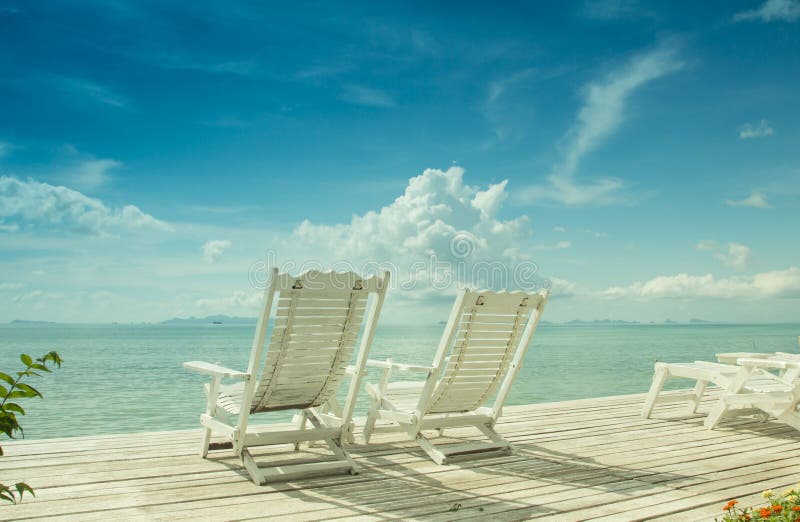 White wooden beach chair with blue sea sky background