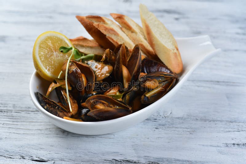 Cozze in conchiglia con crostini e limone in salsa immagini stock libere da diritti