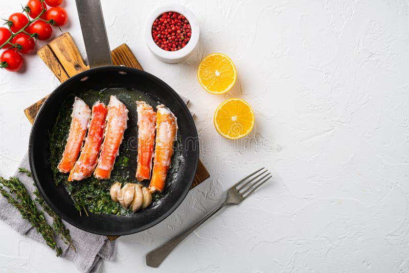 Crab Leg Meat in a Shell with Herbs, in Cast Iron Frying Pan, on White