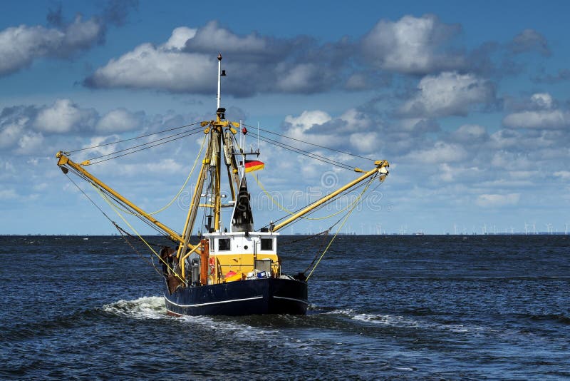 Crabs or shrimp fishing boat on the North Sea under a blue sky w