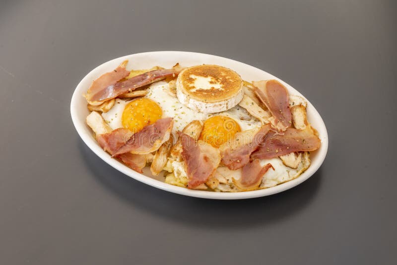 Cracked Egg Tray with Fried Bacon, Goat Cheese and Parsley Stock Photo