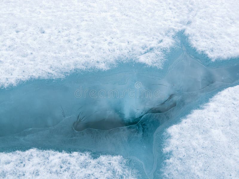 Cracked lake ice sheet nature background pattern stock photos