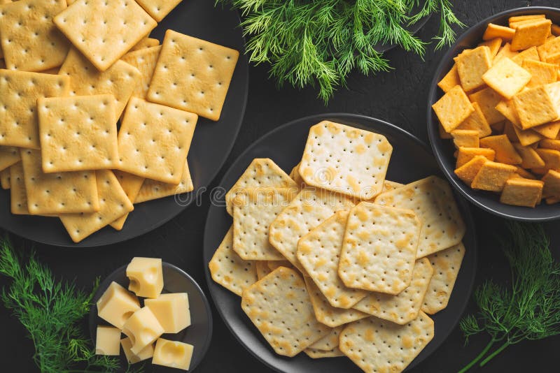 Crackers with Cheese and Greens on a Dark Background Stock Photo