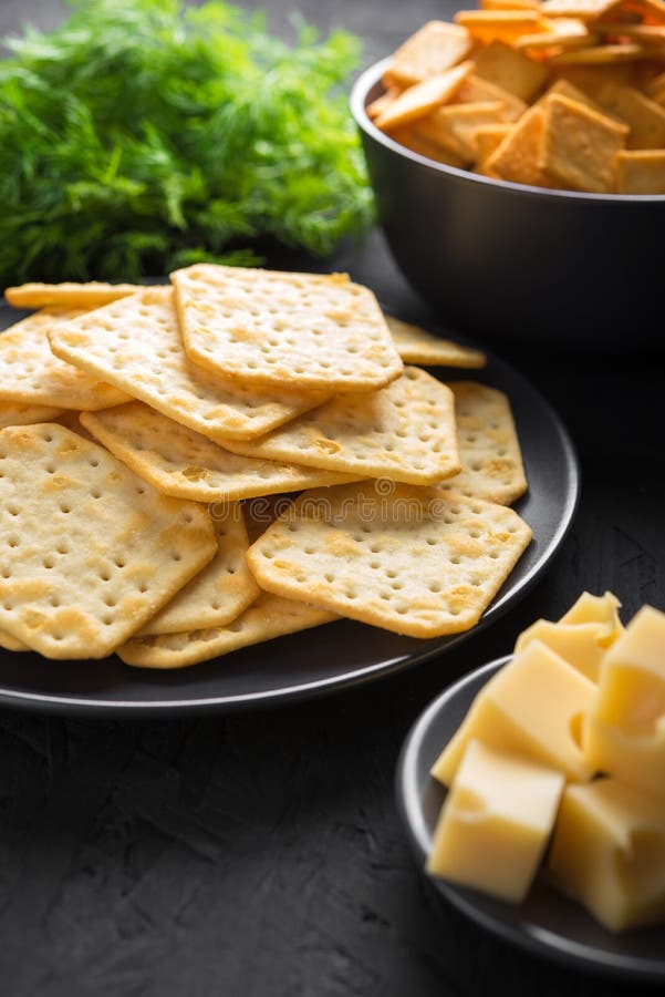 Crackers with Cheese and Greens on a Dark Background Stock Photo