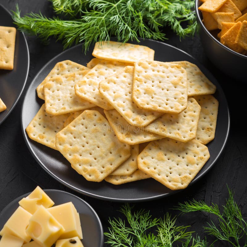Crackers with Cheese and Greens on a Dark Background Stock Photo