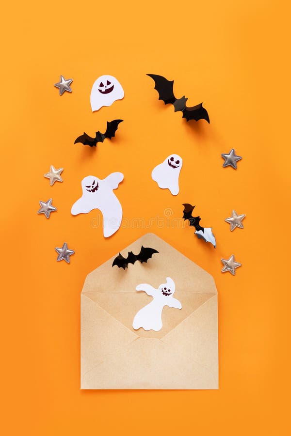 Craft paper envelope and black paper bats fly up on an orange background, top view stock photo Craft paper envelope and black paper bats fly up on an orange background, top view stock photo