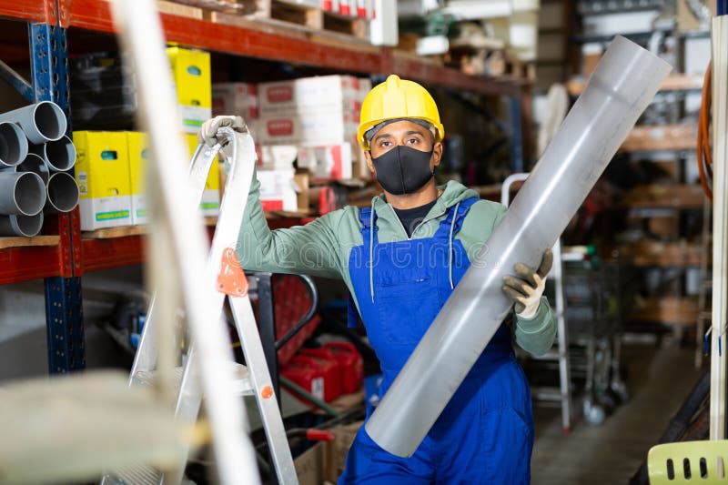 Craftsman in Protective Mask with Plumbing Pipe at Hardware Store Stock