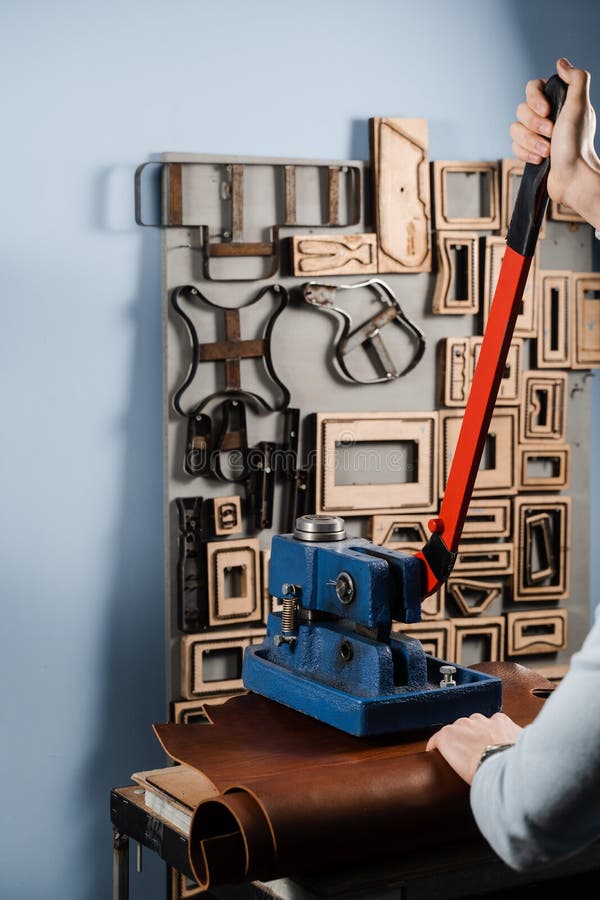 Craftsman is Using Leather Punching Press for Creating Forms from