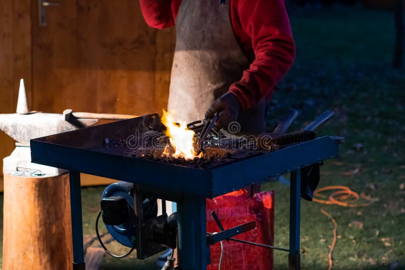 A Craftsman Working with Fire and a Hammer on a Glowing Iron. Middle