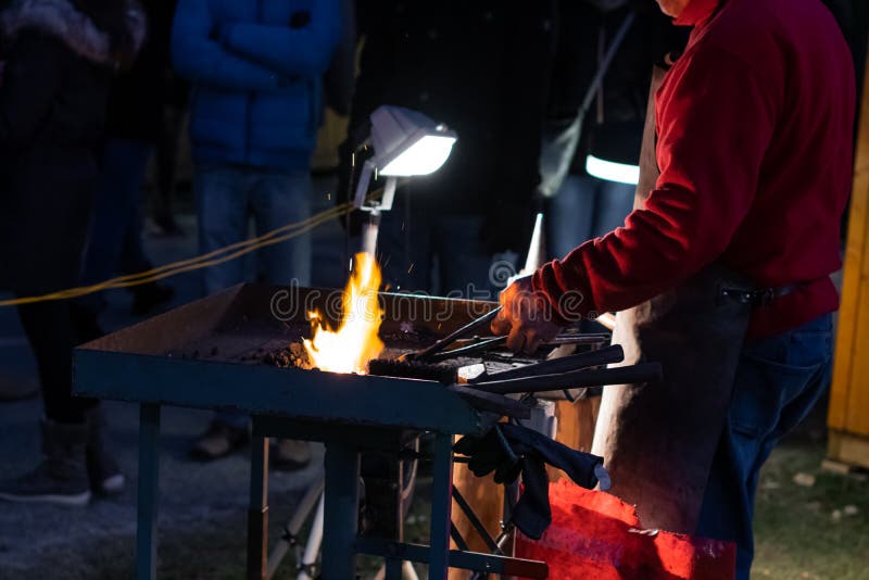 A Craftsman Working with Fire and a Hammer on a Glowing Iron. Middle