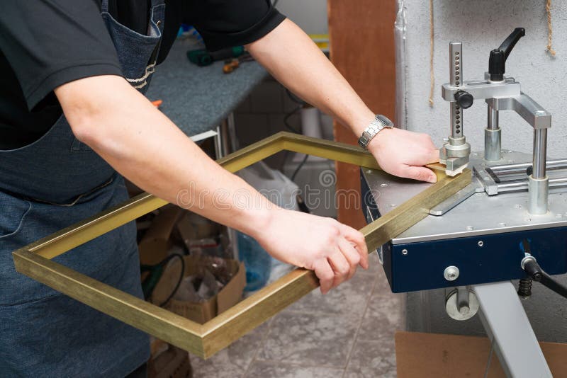 Craftsman working on frame in frameshop. Professional framer. Top view.