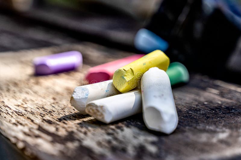 Craie multicolore sur un banc dans le parc jaune blanc rose vert violet. animation pour enfants. aux rayons du soleil d'été