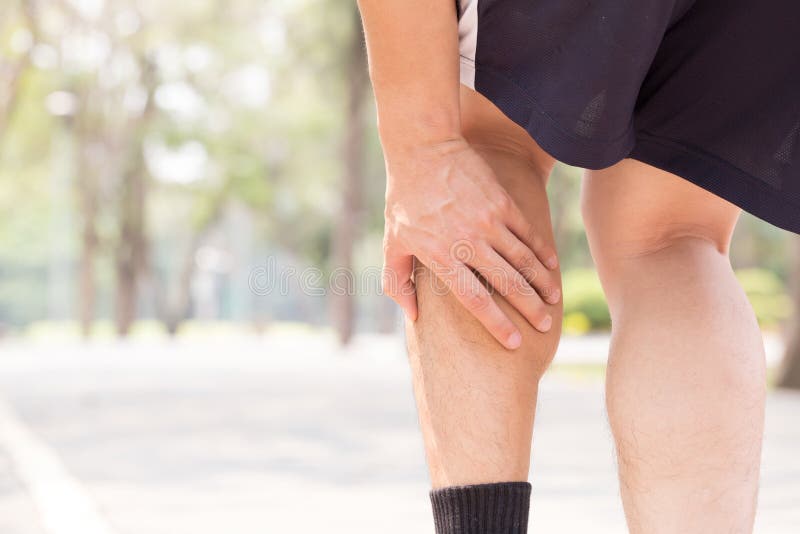 Cramp in leg while exercising. Sports injury concept in park