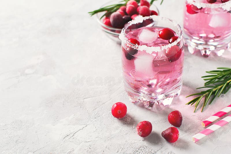 Cranberries cocktails with ice, berries and rosemary