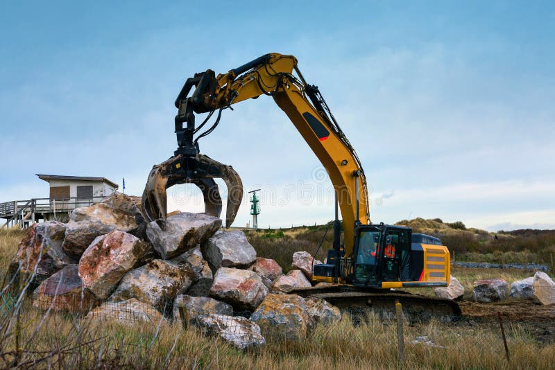 Crane or Excavator Equipped with a Grapple Handling Large Rocks Stock