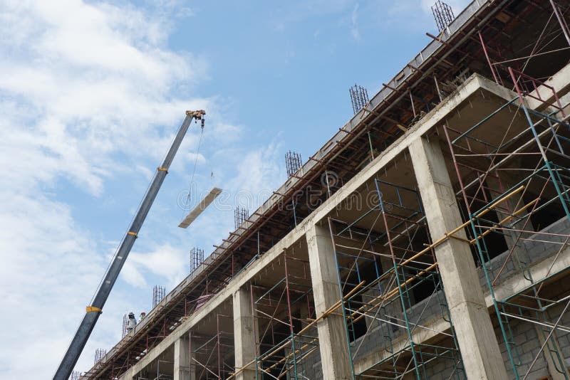 Crane is Lifting a Prestressed Floor To Installation Building. and