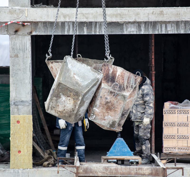 Crane Lowers Containers for Concrete at a Construction Site Stock Image