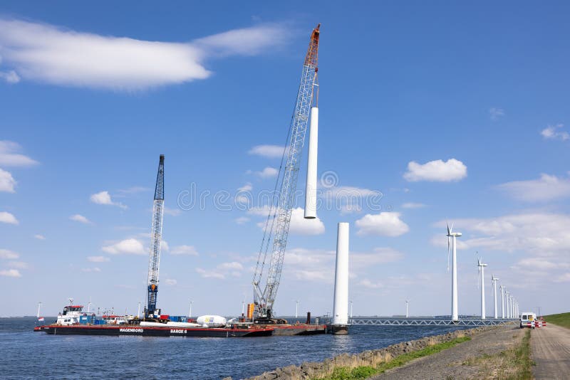 Lelystad, The Netherlands - April 22, 2022: Crane ship and supply vessel busy with demolition old offshore wind turbine. Lelystad, The Netherlands - April 22, 2022: Crane ship and supply vessel busy with demolition old offshore wind turbine