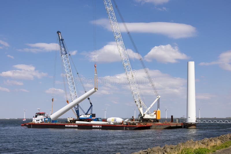 Lelystad, The Netherlands - April 22, 2022: Crane ship and supply vessel busy with demolition old offshore wind turbine. Lelystad, The Netherlands - April 22, 2022: Crane ship and supply vessel busy with demolition old offshore wind turbine